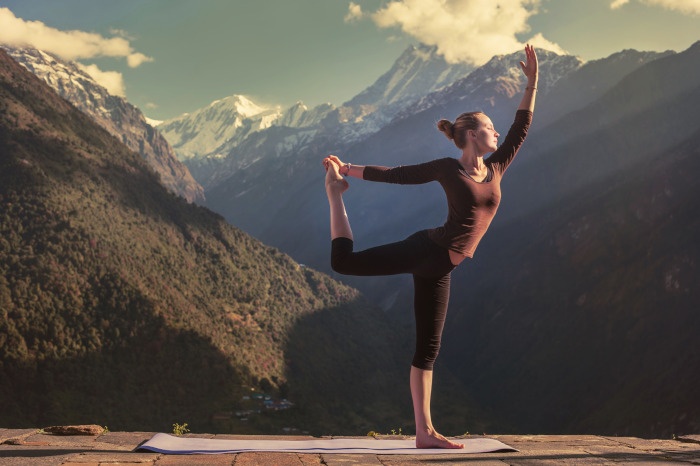 Girl doing a yoga pose in the mountains